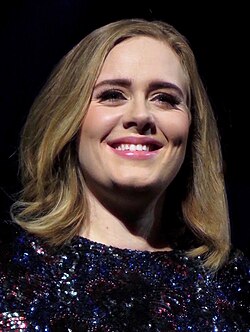Adele looking towards a camera and smiling