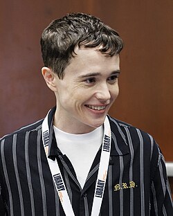 Headshot of Elliot Page at the 2023 National Book Festival. He is a young white man with short dark hair, wearing a white shirt and a dark blazer.