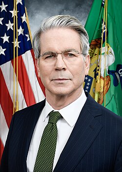 U.S. Secretary of the Treasury Scott Bessent in his official portrait, taken in 2025. He is wearing a dark blue suit, with a green tie.