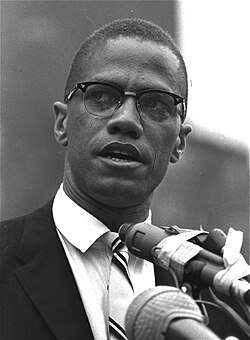 Black-and-white photograph of Malcolm wearing a suit
