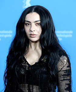 Portrait of Charli XCX, a young woman with long, dark hair