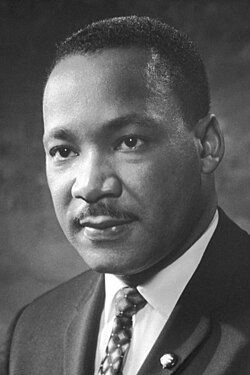 Black-and-white head shot of King wearing a suit and facing left