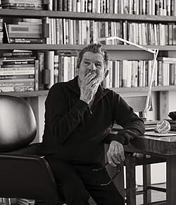 A three-quarters view of Wenner, seated and wearing a polo shirt